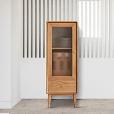 a tall wooden cabinet sitting next to a window