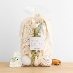 a bag filled with white flowers sitting on top of a wooden table