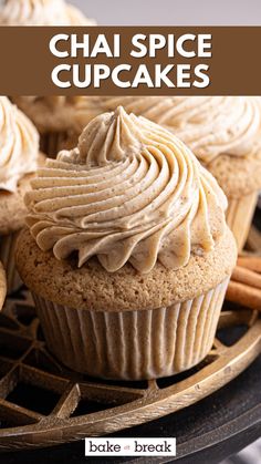 cupcakes on a plate with cinnamon sticks and cinnamon stick in the background text reads chai spice cupcakes