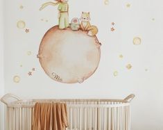 a baby's room with a crib and wall decals