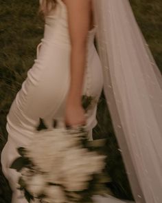 a woman in a wedding dress holding a bouquet