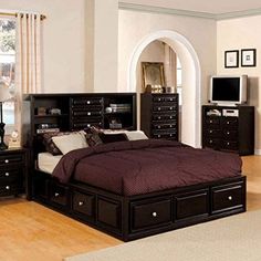 a bedroom with a bed, dresser and tv