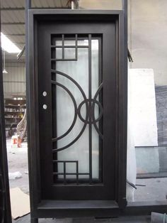 an iron door with glass panels on the front and side doors, in a warehouse