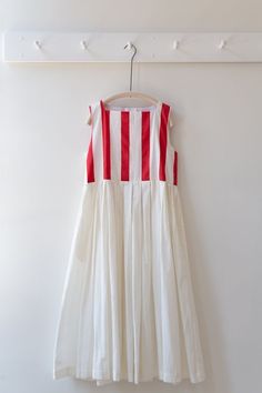 a white and red dress hanging on a hanger