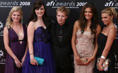 four women and one man posing on the red carpet at an awards event in 2009