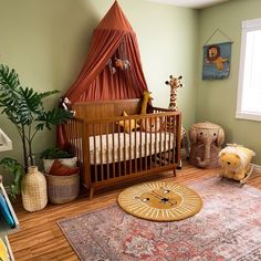 a baby's room with a crib, rug and potted plant in the corner