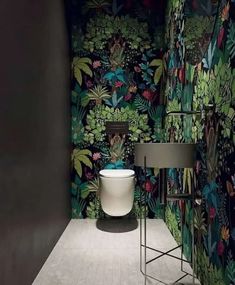 a toilet and sink in a room with floral wallpaper on the walls behind it