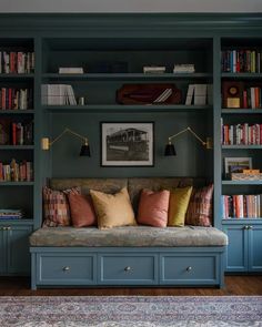 a living room filled with lots of bookshelves next to a couch and rug