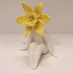 a yellow flower sitting on top of a white table