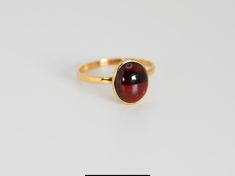 Materials: 14K Gold Ring Size: 6.75 Hallmarks: 14K LNT IN Total Weight (grams): 1.80 Primary Stone(s) Type: Garnet Primary Stone(s) Shape: Oval Cabochon Primary Stone(s) Dimensions: 10.00 mm x 8.00 mm * This item has been evaluated and verified by a GIA Graduate Gemologist.  * All diamond and gemstone grading is done under GIA standards as the mounting permits, where gemstones are present; where mountings impede accurate measurements, (estimated) dimensions are provided. All weights and measurem High Luster Oval Ring In 14k Gold, High Luster 14k Gold Oval Rings, Classic Oval Rings With High Luster, Classic Oval Ring With High Luster, Classic Oval High Luster Ring, Formal Amber 14k Gold Ring, Classic Amber Rings For Formal Occasions, Classic Amber Ring In 14k Gold, Classic Gold Ruby Cabochon Ring