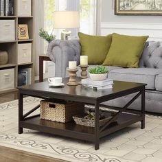 a living room with a couch, coffee table and bookshelf in the corner