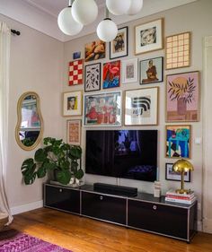 a living room with pictures on the wall and a large flat screen tv in it