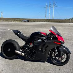 a red and black motorcycle parked in a parking lot