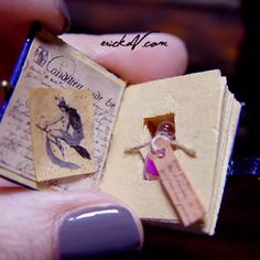 a miniature book with an image of a woman holding it in her hand and the pages are torn off