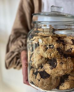 a person holding a jar full of cookies