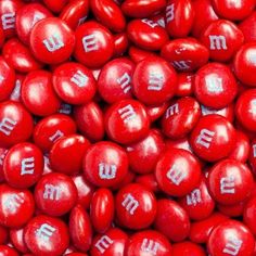 some red candies with white letters on them and one is for m & m