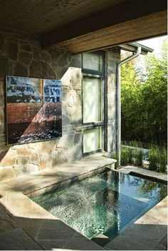 an outdoor hot tub in front of a stone building