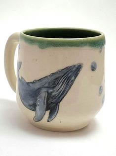 a ceramic mug with a whale painted on it