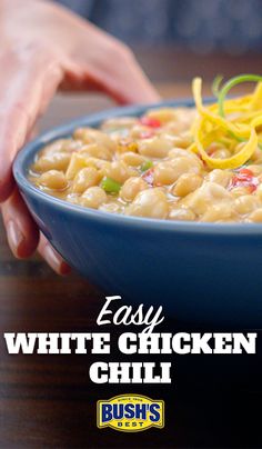 easy white chicken chili in a blue bowl with someone's hand reaching for it