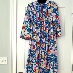 Nwot Vintage House Coat With Zipper 3/4 Length And 2 Side Pockets In A Beautiful Blue Floral Print With Lavender Satin Trim. Size: Medium Fabric: Polyester Blue Nightgown For Spring Loungewear, Long Sleeve Robe For Pajama Party In Spring, Blue Long Sleeve Sleepwear For Vacation, Blue Robe For Spring Daywear, Long Sleeve Blue Robe For Spring, Blue Spring Vacation Nightgown, Floral Print Long Sleeve Sleepwear For Vacation, Blue Long Sleeve Robe For Spring, Blue Spring Robe For Loungewear