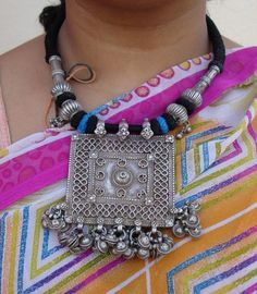 "Antique Tribal old silver necklace from Rajasthan India. These necklaces worn by Banjara tribal people from Rajasthan Desert. One big size heavy square old silver pendant re strung together strongly with four old silver beads ,end finish with loop and silver ball. Attached noisy bells in all the bottom loops. The middle big pendant called (silver house amulet) a symbol of family unity represented by walled-in rectangle, the amulet uses stamped floral units to cover joins. See similar sample in Traditional Silver Necklace With Square Pendant, Traditional Rectangular Necklace For Festivals, Traditional Silver Rectangular Pendant Jewelry, Traditional Jewelry With Large Square Pendant, Traditional Silver Rectangular Necklace, Rajasthan Desert, Family Unity, Big Pendant, Silver Necklace Pendant