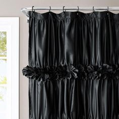 a black curtain hanging on the side of a window