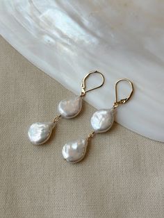 ARIELLE PEARL EARRINGS These gorgeous Pearl double Coin Pearl drop earrings are made with stunning quality teardrop Coin Pearls! These would make lovely bridal earrings, or wear them to elevate any casual outfit. The Leverback closure stays securely closed and lightweight for comfort. These are some of the nicest quality Coin Pearls I have come across! Pair them with the matching Coin Pearl Necklace to create a dreamy matching set! Details: * AAA quality 14mm genuine Coin Pearls * 2.25 inch length  * 14K Gold Filled or 925 Sterling Silver accents * 14/20 gf or 925 stamp for authenticity * Made with all hypoallergenic materials 🤍 *Please note for the health and safety of my customers, and to uphold the highest quality standards - these earrings are final sale - please dm me with any questi Pearl Drop Earrings For Wedding, Pearl Drop Earrings For Wedding Fine Jewelry, Wedding Fine Jewelry Pearl Drop Earrings, Wedding Jewelry With Matching Pear-shaped Earrings, Fine Jewelry Long Drop Wedding Earrings, Yellow Gold Teardrop Linear Earrings For Wedding, Wedding Yellow Gold Linear Teardrop Earrings, Hypoallergenic Yellow Gold Pearl Earrings For Wedding, Fine Jewelry Ear Wire For Wedding