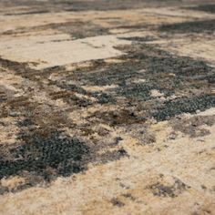 an area rug with various colors and patterns on it, including brown, beige, black and white