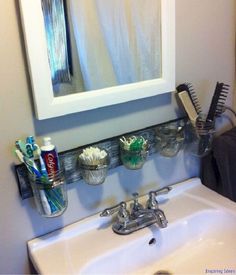 a bathroom sink with toothbrushes, combs and other items