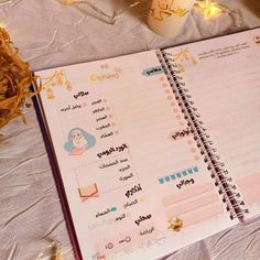 an open planner book sitting on top of a table next to some eggs and candles