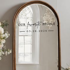 a mirror with the words our favorite people on it and flowers in front of it