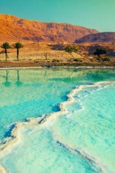 the water is very blue and green with mountains in the background