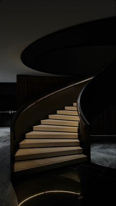 a spiral staircase in the dark with light coming from it's top and bottom