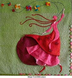 a woman's dress and hat on a quilted wall hanging