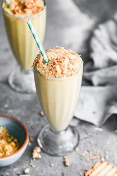 two glasses filled with drinks and topped with toasted crumbs next to a bowl of crackers