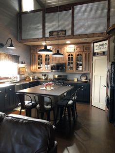 a large kitchen with wooden cabinets and black leather chairs in front of the counter top