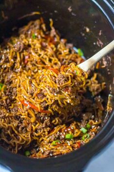 a slow cooker filled with noodles and meat