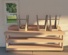 three vases sitting on top of a wooden shelf in front of a window,