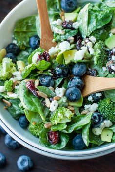 a salad with blueberries, avocado and feta cheese in a bowl