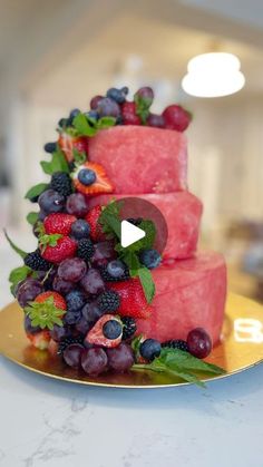 a watermelon and berry cake on a gold plate