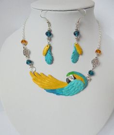 Blue and gold macaw set - necklace, earrings, handmade. Parrot jewellery I offer beautiful unique necklace and earrings- wholy handmade of highest quality polymer clay. Not painted. Stylized to blue and gold macaw. It's solid and resistant to water and dirt. Suspended on antyalergic chain with beads. Safely packed in a gift box. Ideal for people who love birds, and not only :) Hand Painted Gold Dangle Jewelry, Gold Hand Painted Dangle Jewelry, Hand Painted Sterling Silver Dangle Jewelry, Unique Hand Painted Gold Jewelry, Unique Yellow Jewelry With Matching Earrings, Unique Bird Design Pendant Jewelry, Artisan Yellow Dangle Jewelry, Artistic Yellow Jewelry With Matching Earrings, Unique Hand Painted Yellow Jewelry