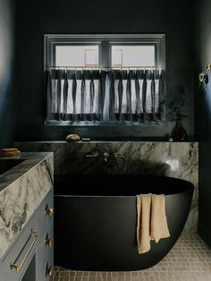 a black bath tub sitting next to a window