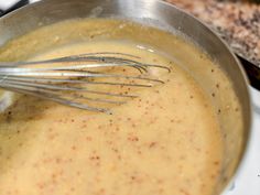 a pot filled with sauce and whisk on top of a stove