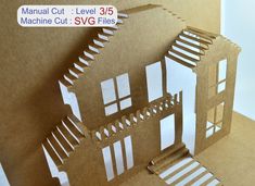 a cut out paper house sitting on top of a piece of cardboard with the words manual cut level 3 / 5 machine cut svg files