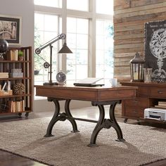 a wooden desk sitting on top of a rug next to a book shelf filled with books