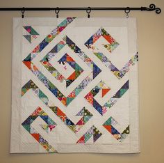 a quilt hanging on a wall next to a pair of scissors