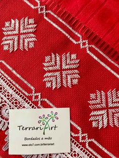 a red and white scarf with snowflakes on the border, next to a tag that says terrari art