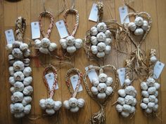 several garlic bulbs are tied together with twine and tags on them, along with price tags