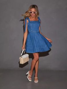 The Denim Bow Shoulder Mini Dress adds a playful twist to casual chic. Crafted from classic denim, this mini dress features charming bow details on the shoulders, giving it a feminine and flirty touch. The mini silhouette offers a youthful and fun vibe, while the sturdy denim fabric ensures a relaxed yet stylish fit. Perfect for weekend outings or casual get-togethers, this dress effortlessly combines comfort with a cute, trendy look. Casual Day Out Dress With Bow Straps, Mini Dress With Bow For Day Out, Casual Dresses With Bow Straps For Day Out, Bow Mini Dress For Day Out, Casual Mini Denim Dress For Party, Trendy Mini Dress With Tie Straps, Casual Sleeveless Mini Dress With Bow Straps, Casual Medium Wash Mini Dress For Party, Chic Denim Blue Mini Dress