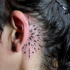 a woman's behind the ear tattoo with black dots on her left side and an intricate starburst